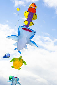 Low angle view of balloons flying against sky