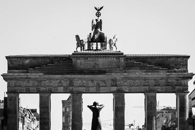 Statue in city against clear sky