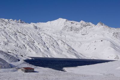 Scenic view of snowcapped mountains against clear blue sky