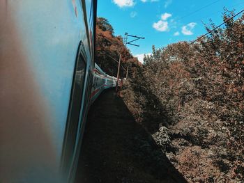 Railroad tracks by trees against sky