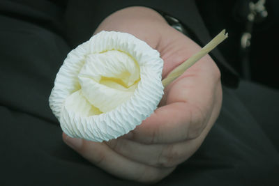 Close-up of hand holding paper craft flower for funeral