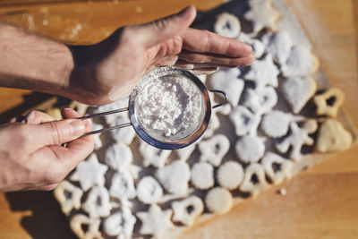 Preparation of christmas sweets during advent. powdered sugar falling on linzer cookies.