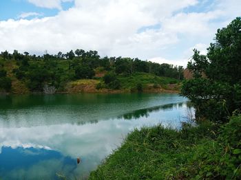 Scenic view of lake by trees against sky