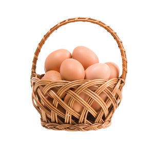 Close-up of eggs in basket against white background