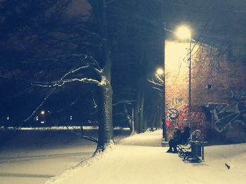 Snow covered road in city at night