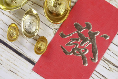 Close-up of ingot feng shui and red card on table