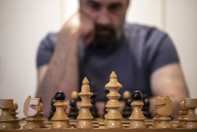 Full length of man playing chess against blurred background