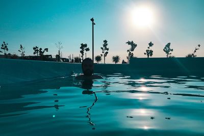 Man in swimming pool against sky