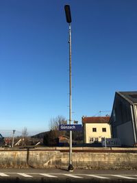 Low angle view of street light against blue sky