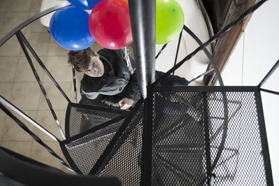 High angle view of man sitting on spiral staircase