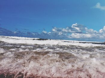 Scenic view of beach against blue sky