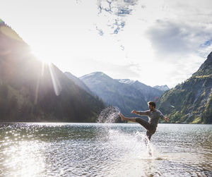 Austria, tyrol, hiker splashing in mountain lake