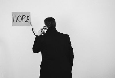 Rear view of man standing against white background