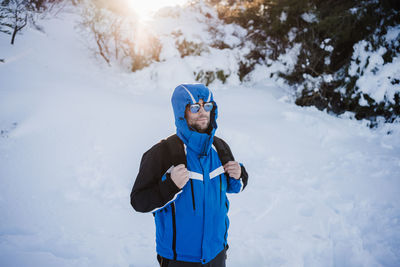 Man standing on snow covered land during winter