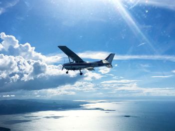 Airplane flying over sea against sky