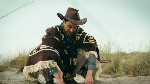 Man digs with his hands in the sand