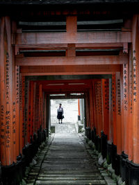 Rear view of man walking in temple building