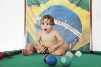 Boy playing with balls on pool table