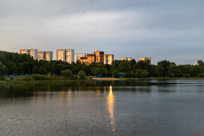 Lake by buildings against sky in city