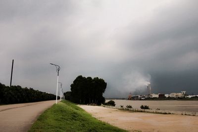 Empty road against cloudy sky