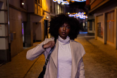 Portrait of young woman standing at home