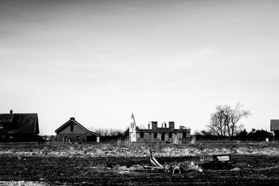 Houses on field against clear sky