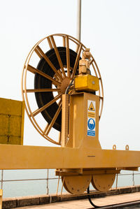 Low angle view of yellow wheel against clear sky