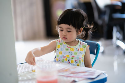 Portrait of cute girl preparing food on table