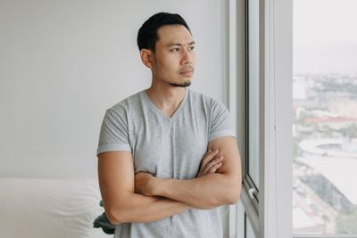 Portrait of young man looking through window