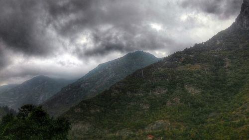 Scenic view of mountains against cloudy sky