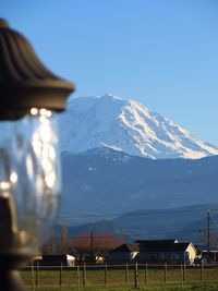 Close-up of lamp with snowcapped mt rainier in background against clear sky