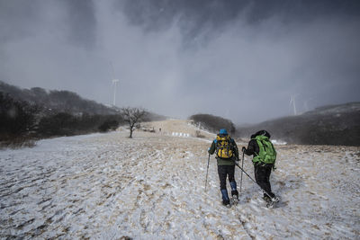 Rear view of people on snow covered land