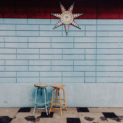 Empty chairs and table against wall