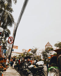 People walking on road against sky in city