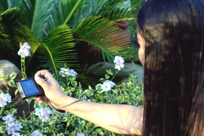 Midsection of woman photographing with mobile phone