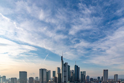 Modern buildings in city against cloudy sky