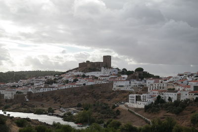 High angle view of buildings in town against sky