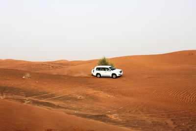 Vintage car on desert against clear sky