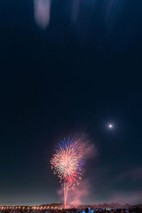 Low angle view of firework display at night