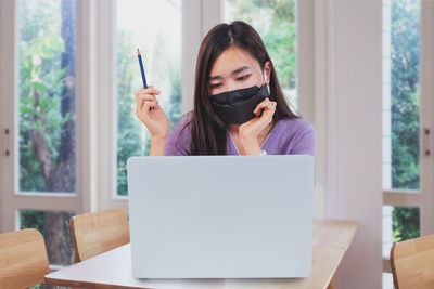 Portrait of woman using mobile phone at home