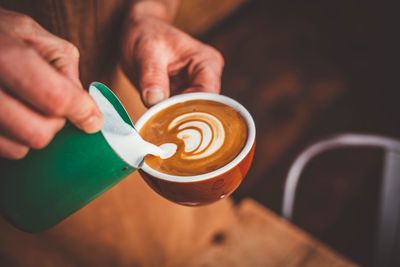 Cropped image of hand holding coffee cup