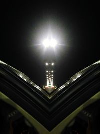 Low angle view of illuminated lights against sky at night