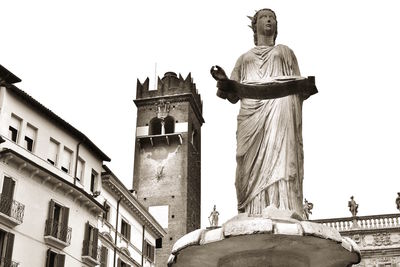 Low angle view of statue against building against clear sky