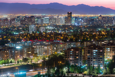 High angle view of illuminated buildings in city at dusk