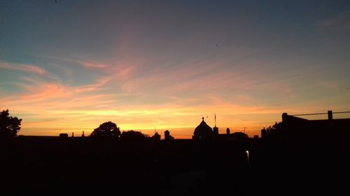 Silhouette buildings against sky during sunset