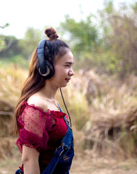 Side view of young woman standing on field