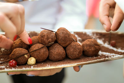 Close-up of hand holding chocolate cake