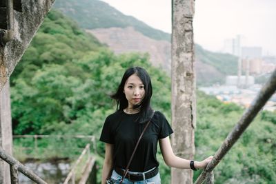 Portrait of confident beautiful woman standing in abandoned building