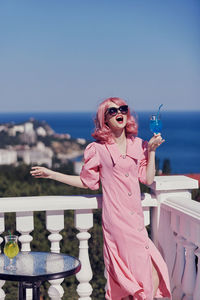 Portrait of woman standing against sea