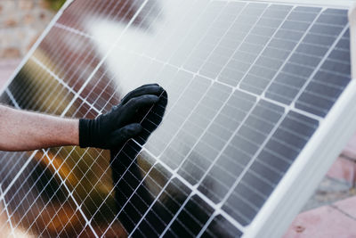 Close up view of mature technician man checking solar panels for self consumption energy. renewable